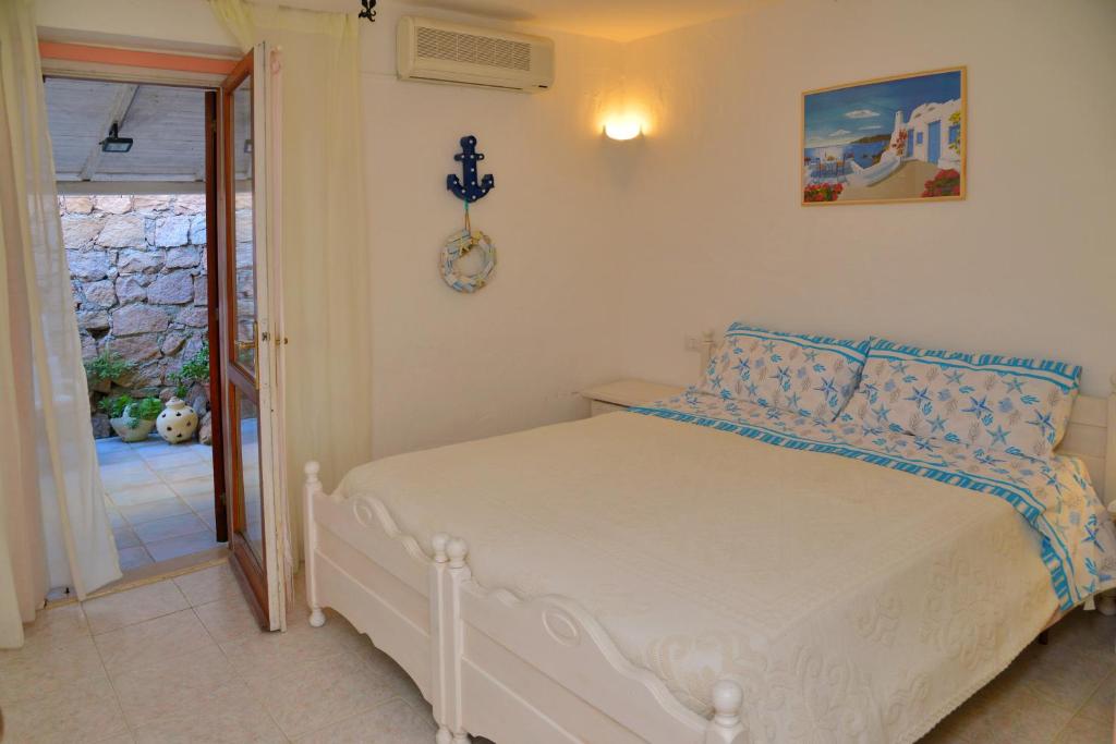 um quarto com uma cama branca e almofadas azuis em Casa UGB em Cannigione