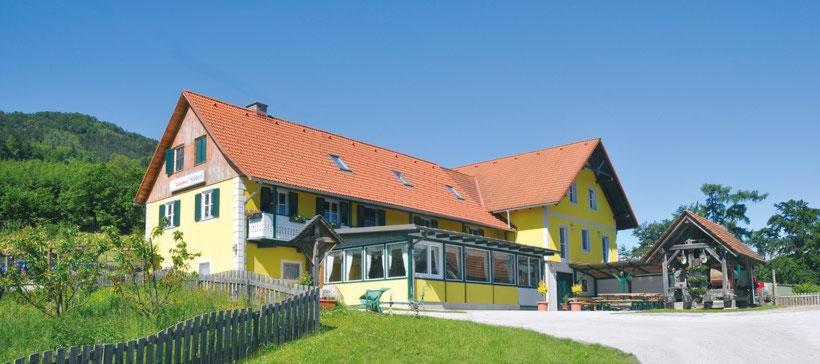 una gran casa amarilla con techo rojo en Biohof Laibacher, en Stubenberg
