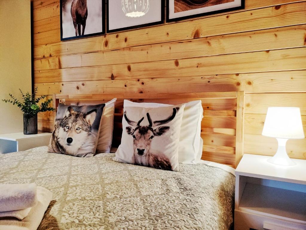 a bedroom with a bed with two deer pillows at Pokoje i Domki Na Szlaku in Polanica-Zdrój