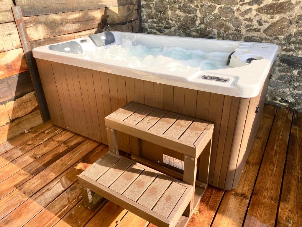 bañera grande con suelo de madera en Le SPA de l’Abbaye, en Saint-Junien