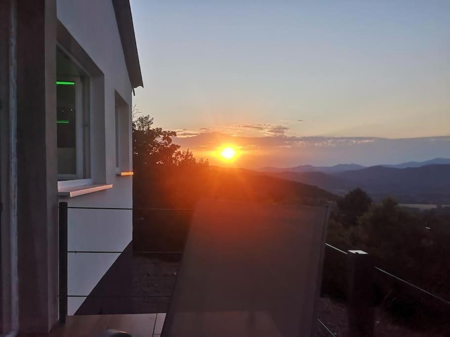 a sunset seen from a window of a building at Csudahely - WonderPlace in Dunabogdány