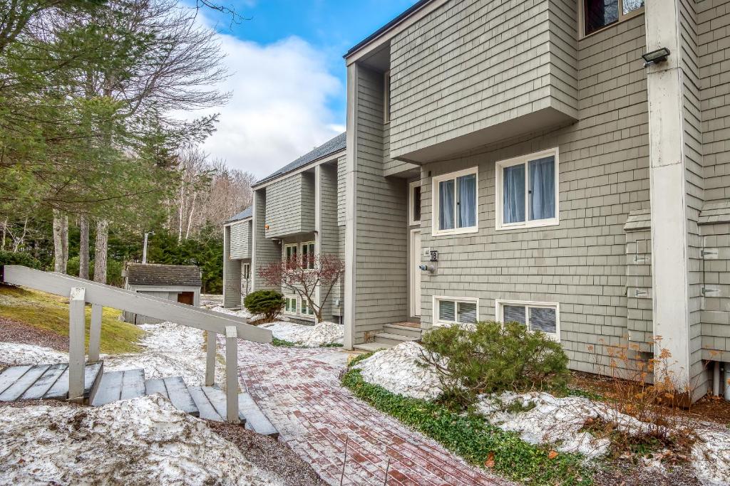 una casa con una valla delante de ella en R18 Affordable Ski-in Ski-out Bretton Woods Townhome mountain views, en Carroll