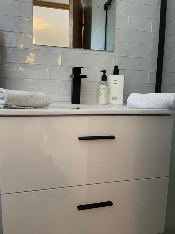 a bathroom vanity with a white sink and a mirror at Chambre d’hôtes in Saintes-Maries-de-la-Mer