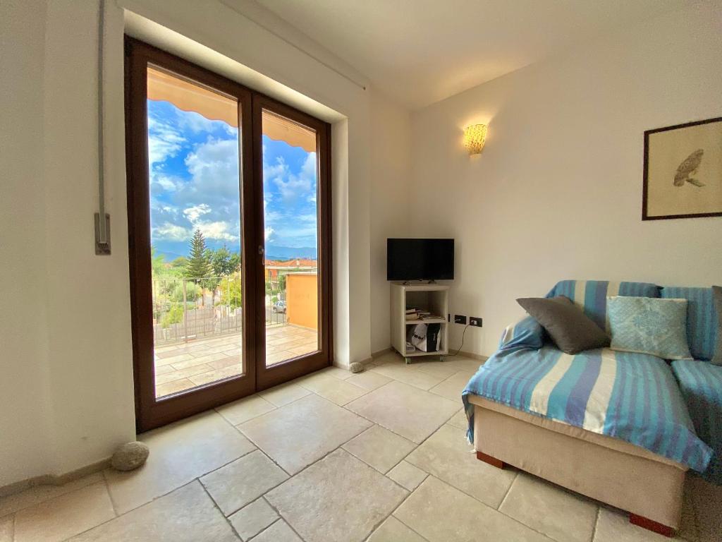 Un dormitorio con una cama y una ventana grande. en Jennas- Blue Apartment, en Àrbatax