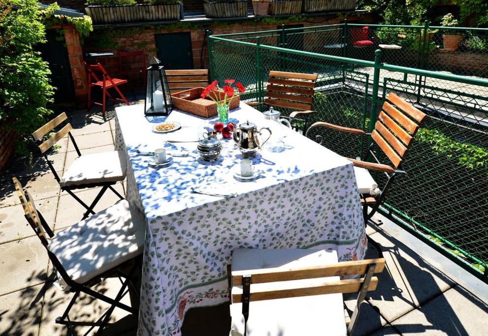 een tafel met een witte tafellaken op een patio bij Green haven roofgarden penthouse in central area in Wenen