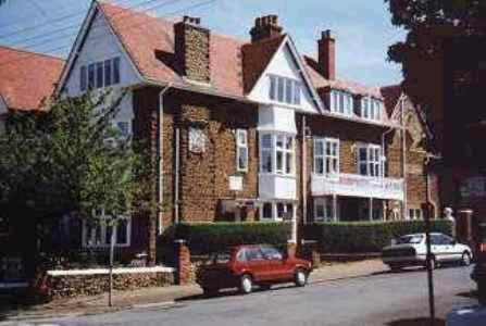 un camión rojo estacionado frente a una casa grande en The Gables, en Hunstanton