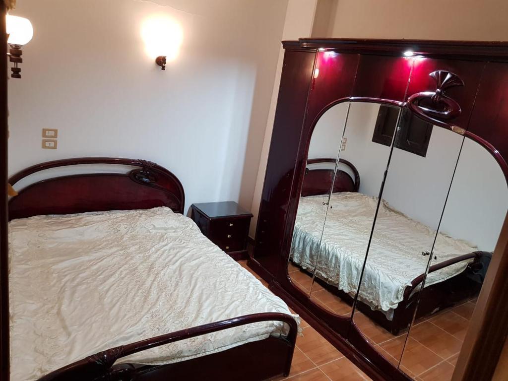 a bedroom with two beds and a mirror at Azzam Guest House 2 families only in Fayoum