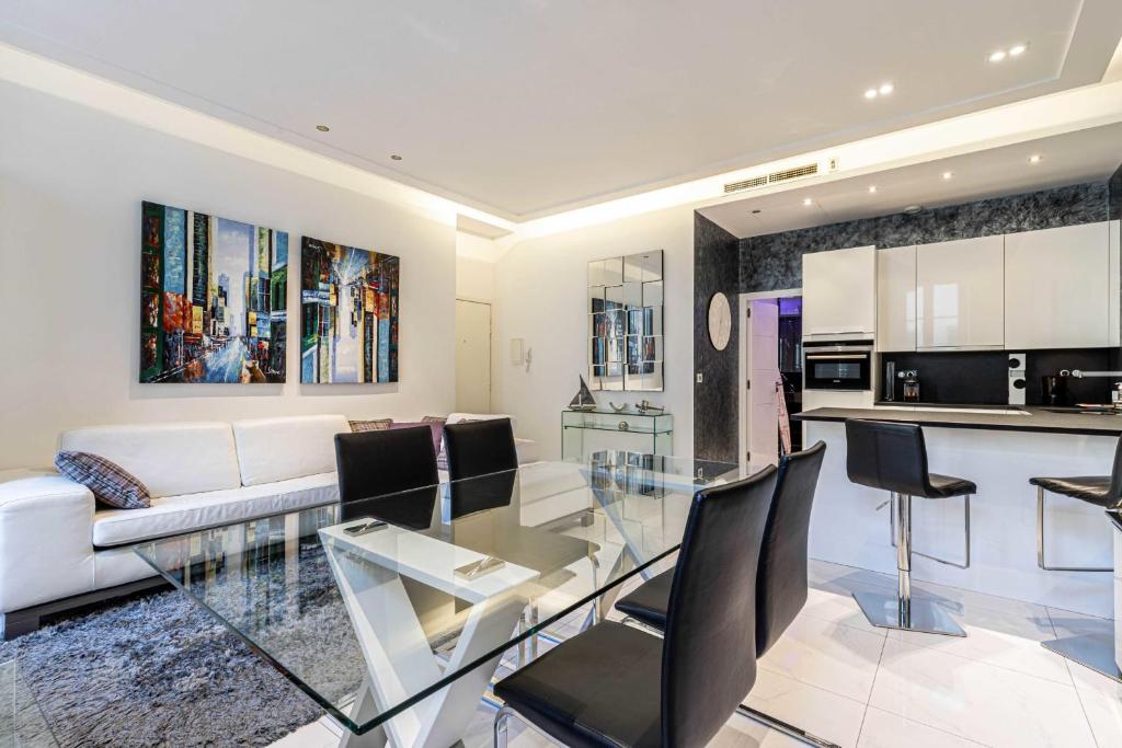 un salon avec une table en verre et une cuisine dans l'établissement Large renovated studio - rue Hoche - Cannes center, à Cannes