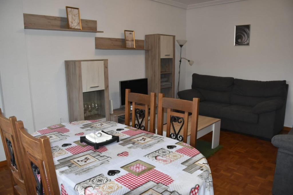 - un salon avec une table et un canapé dans l'établissement Apartamento Virgen de las Viñas, à Aranda de Duero