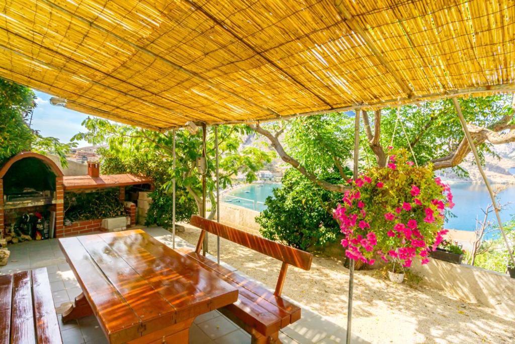 uma mesa de piquenique e um banco debaixo de um guarda-chuva amarelo em Zlatna Vala Relaxation in a very quiet location em Metajna