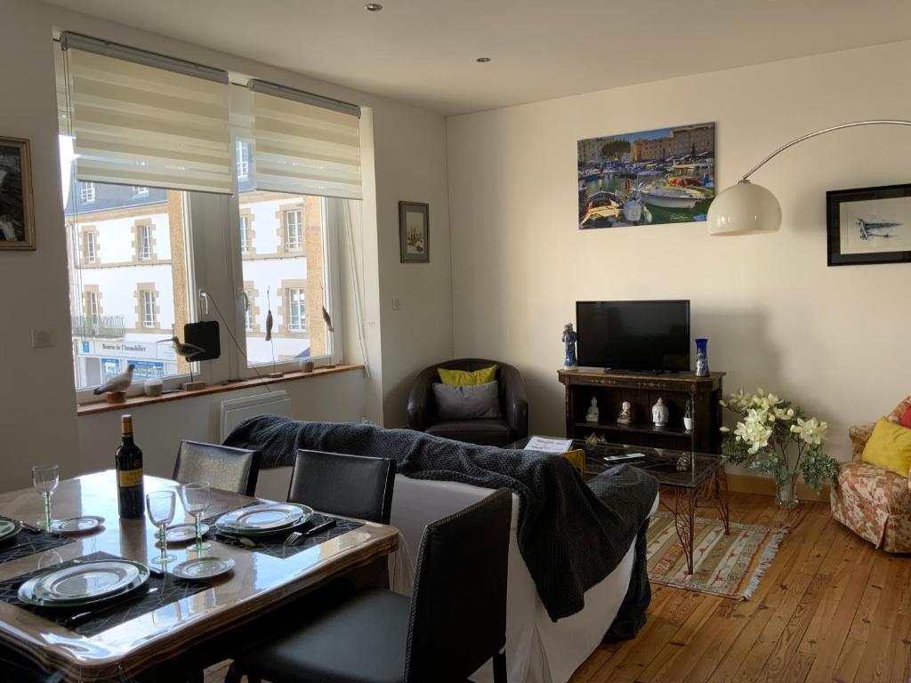 a living room with a couch and a table at Appartement de charme - Port d'Audierne in Audierne