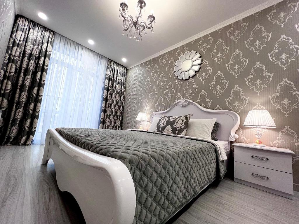 ein Schlafzimmer mit einem großen Bett und einem Kronleuchter in der Unterkunft Красивая квартира в центре города с балконом in Odessa