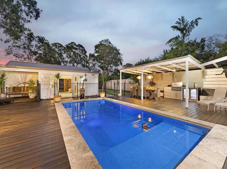 a house with a swimming pool and a deck at Sunset on Noosa Chalet in Noosa Heads