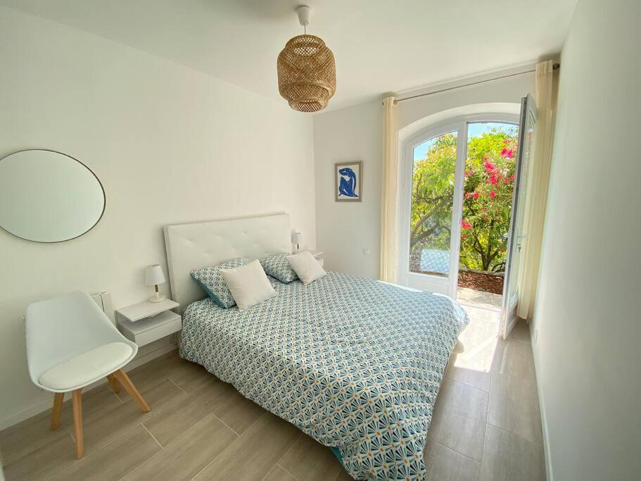 ein Schlafzimmer mit einem Bett, einem Stuhl und einem Fenster in der Unterkunft 06Q - Biot - belle villa provençale avec piscine in Biot