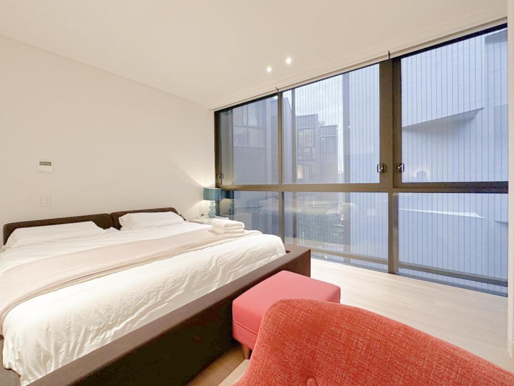 a bedroom with a bed and a large window at Pyrmont Town House Homestay in Sydney
