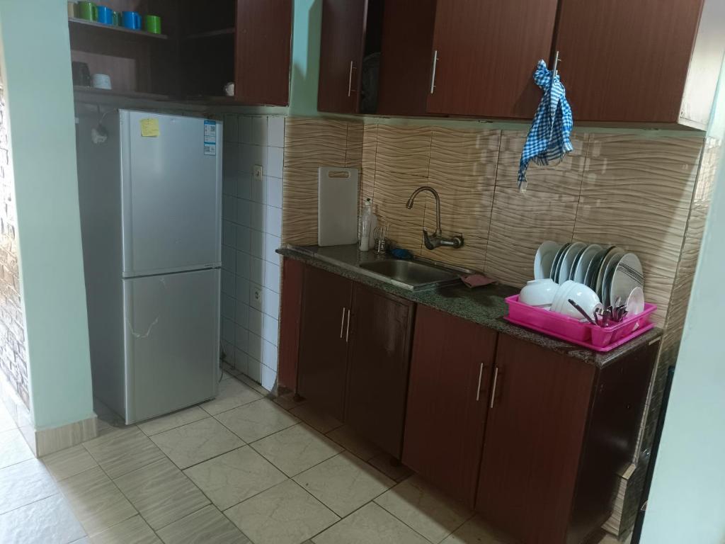 a small kitchen with a sink and a refrigerator at Puma Garden and Suites - Nyarutarama in Kigali
