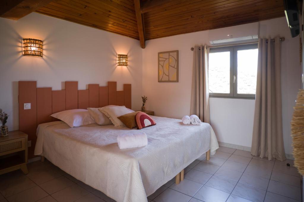 a bedroom with a large bed and a window at Hôtel - Restaurant U Santu Petru in Saint-Florent