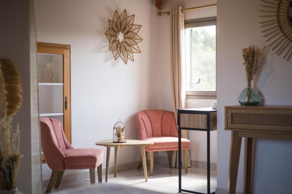 a room with two chairs and a table and a window at Hôtel - Restaurant U Santu Petru in Saint-Florent