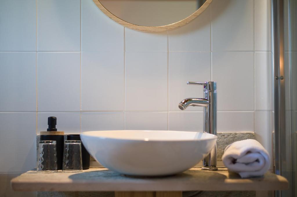 a bathroom with a bowl sink and a mirror at Hôtel - Restaurant U Santu Petru in Saint-Florent