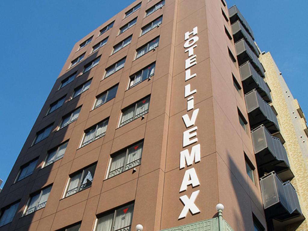 東京的住宿－HOTEL LiVEMAX BUDGET Higashi Ueno，一座高大的棕色建筑,上面有标志