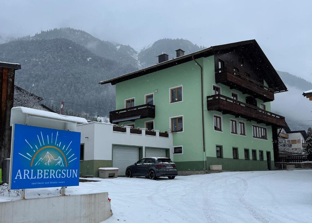 un edificio verde con un coche aparcado delante de él en Arlbergsun, en Pettneu am Arlberg