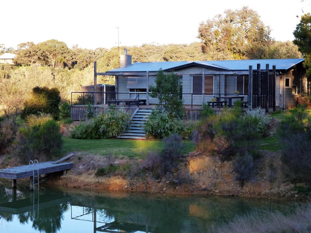 a house sitting on the side of a river at Lavandula Country House in Hepburn Springs
