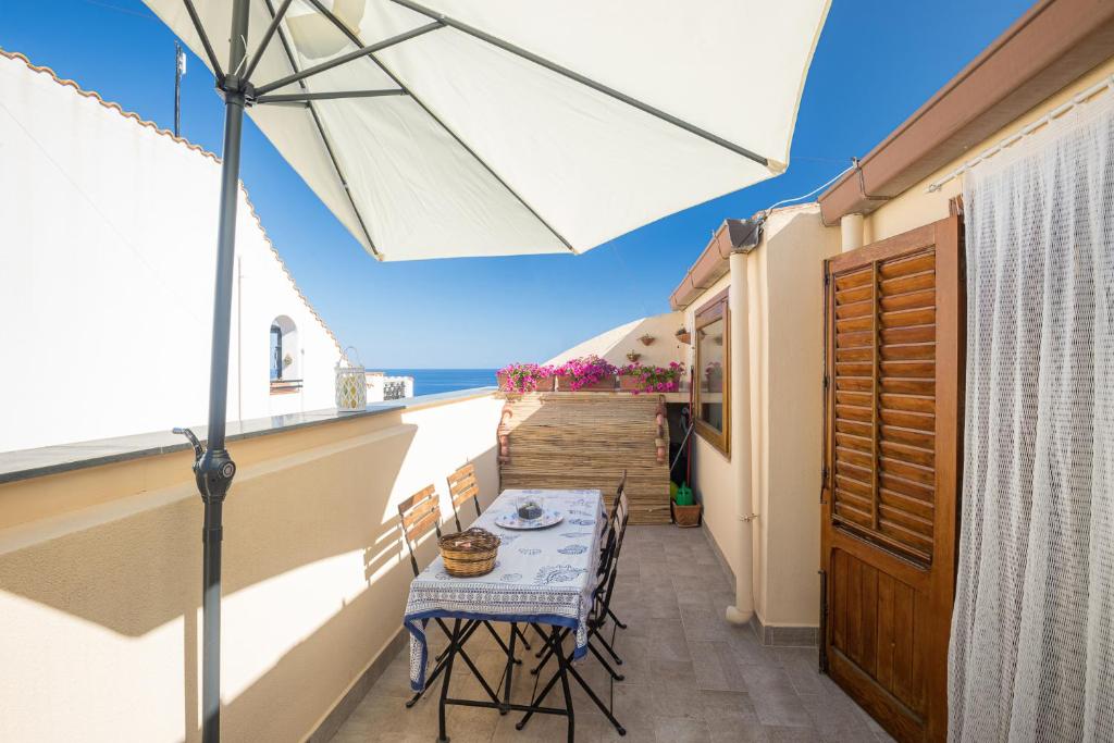 a table and chairs on a balcony with an umbrella at Casa Clelia Piazza in Ustica