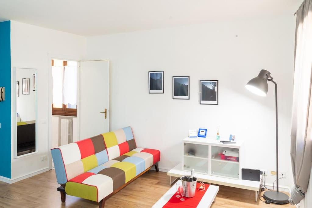 a living room with a colorful couch and a table at Guest House San Pietro in Reggio Emilia