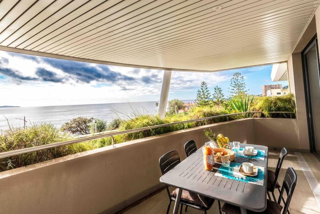 stół i krzesła na balkonie z widokiem na ocean w obiekcie Ajaccio, les Cyclades, magnifique appartement vue mer w Ajaccio