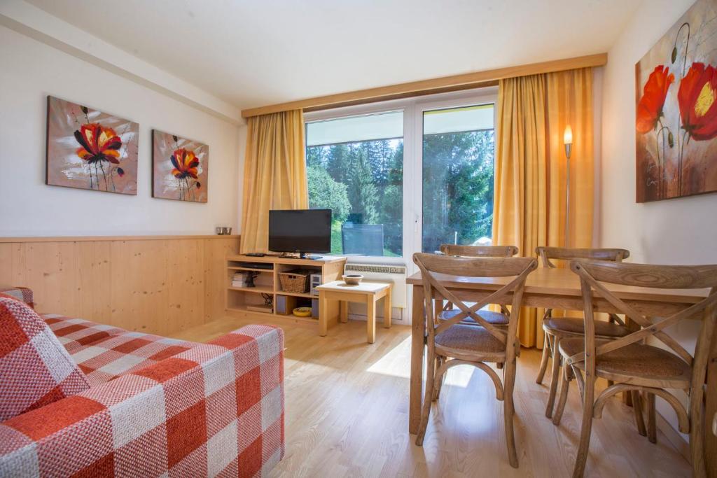 - un salon avec un canapé et une table avec des chaises dans l'établissement Appartement Wiesberger 62 Top 6, à Königsleiten
