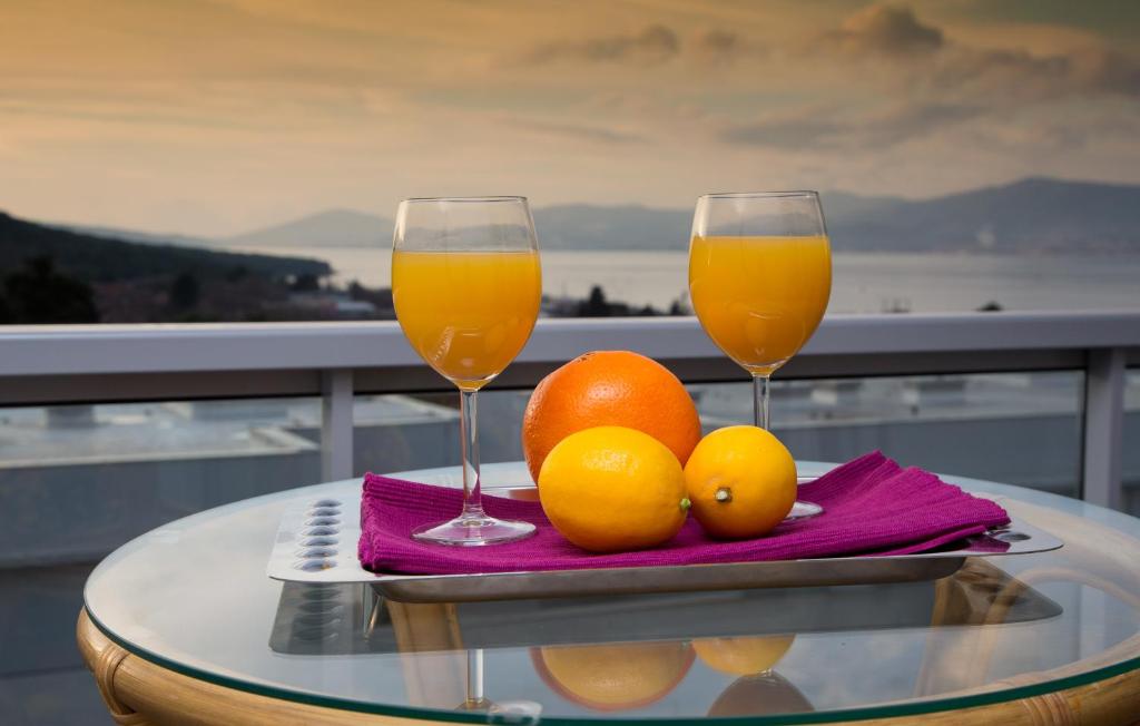 twee glazen sinaasappelsap en sinaasappels op een tafel bij Apartment Belavista in Split
