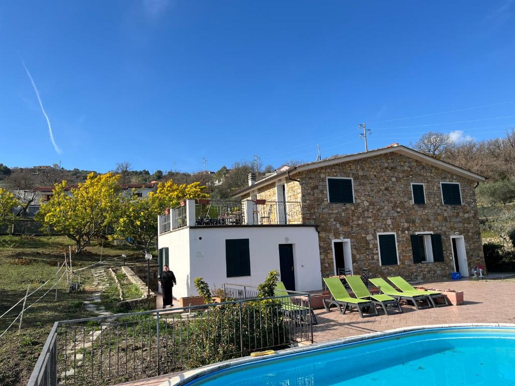 a villa with a swimming pool in front of a house at Agriturismo Le Mimose in Imperia