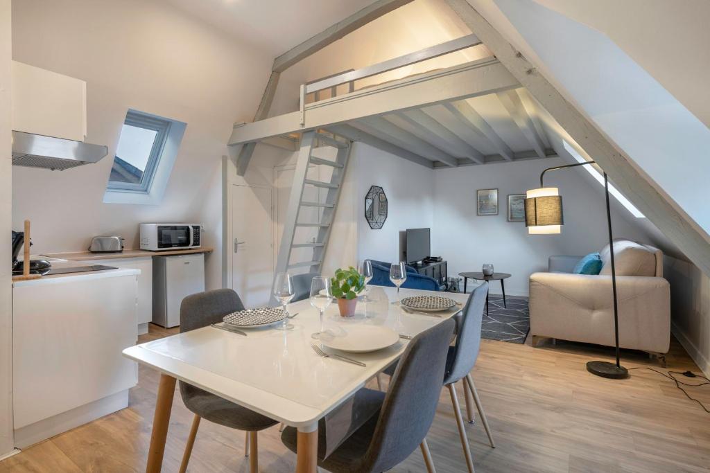 een keuken en eetkamer met een tafel en stoelen bij Charmant appartement en plein centre du Pouliguen! in Le Pouliguen