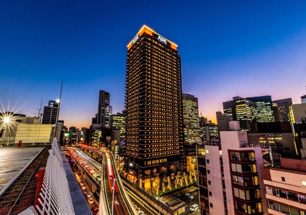 une ligne d'horizon avec un grand bâtiment et une circulation dans l'établissement APA Hotel & Resort Osaka Umeda-eki Tower, à Osaka