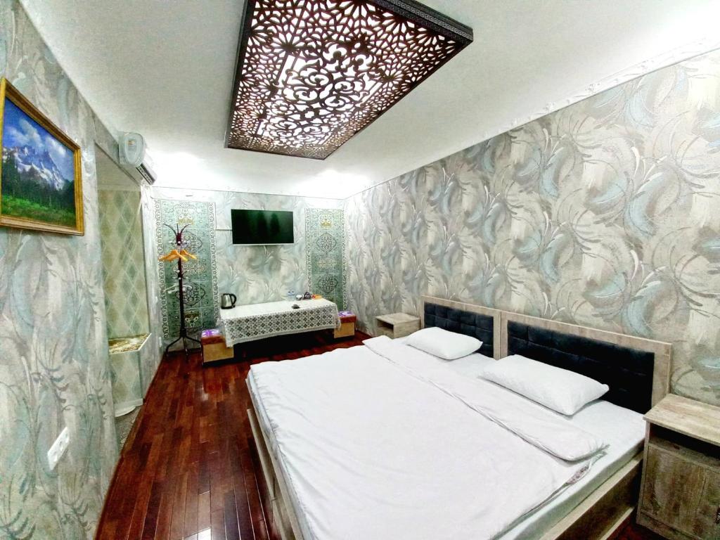 ein Schlafzimmer mit einem Bett und einem Waschbecken darin in der Unterkunft Colibri Traditional Guest house in Samarkand