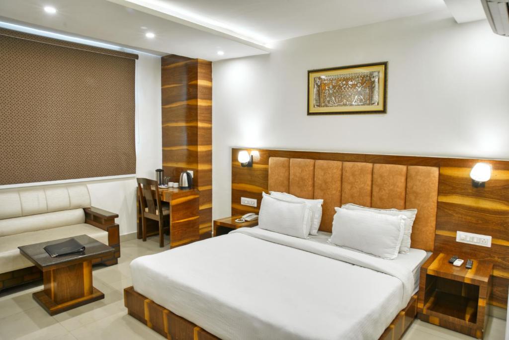 a hotel room with a bed and a desk at Height View Residency in Dehradun