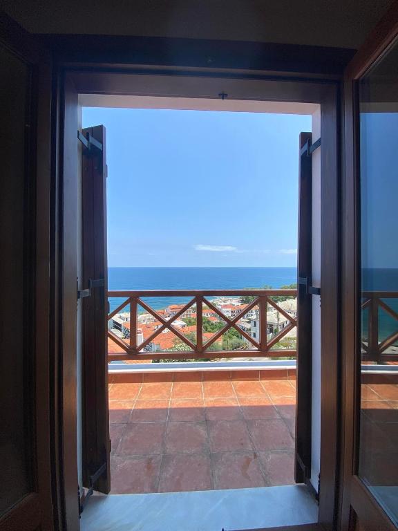 an open door to a balcony with a view of the ocean at Luna Bay in Agios Ioannis Pelio