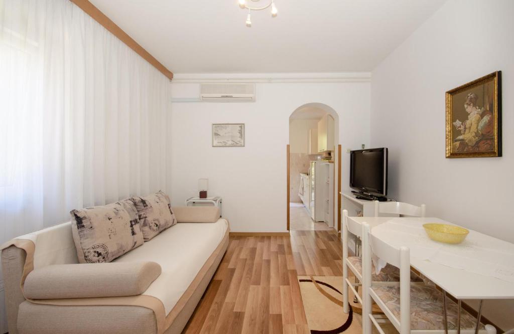 a white living room with a couch and a table at Apartments Bungavilia in Rovinj