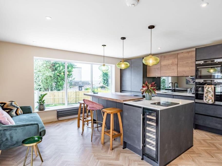 a kitchen and living room with a large window at Northdene - 5 star Lake District Cottage in Cockermouth