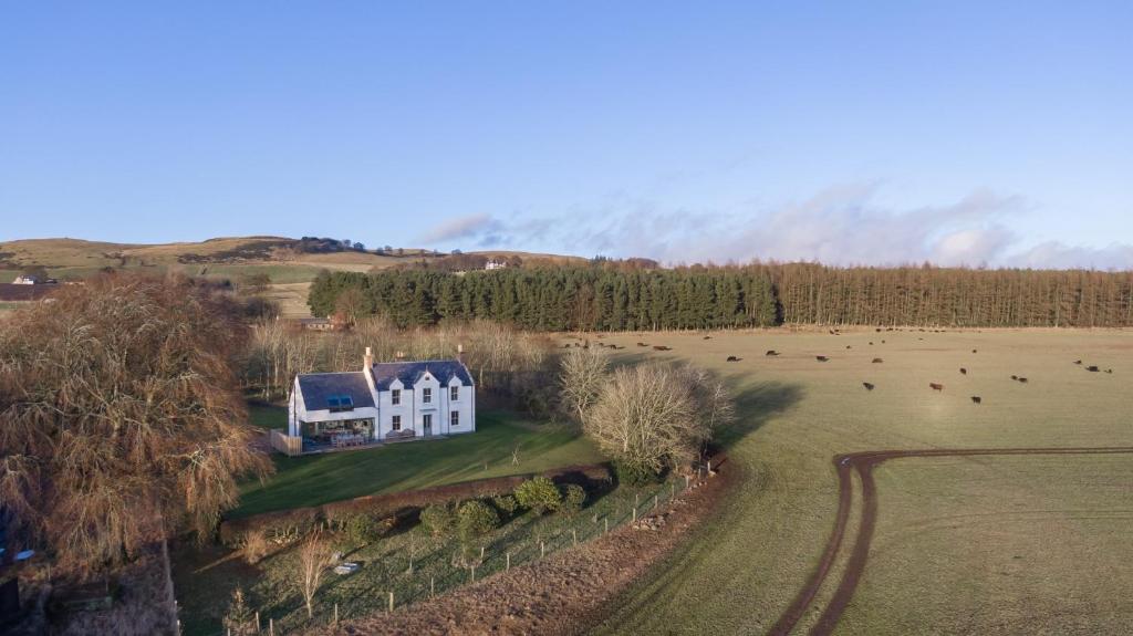 una vista aérea de una casa blanca en un campo en Greenmyre Farmhouse with Hot Tub en Kirriemuir