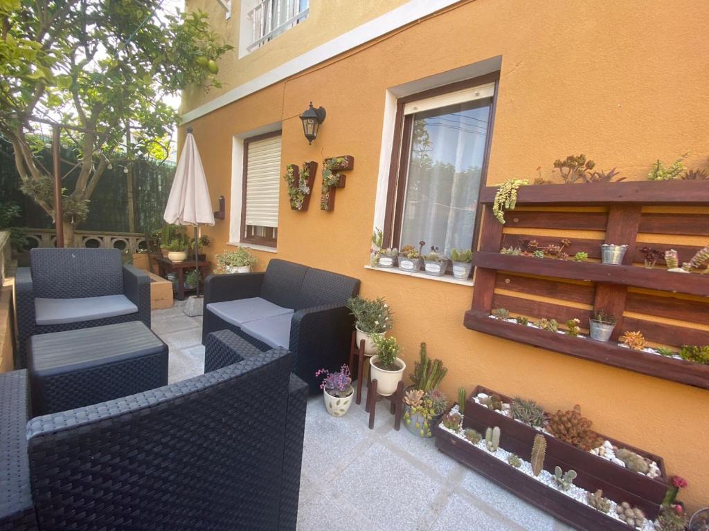 a patio with two chairs and a window and plants at Bajo con terraza a 5 min de la playa (3 hab-6 per) in Santander