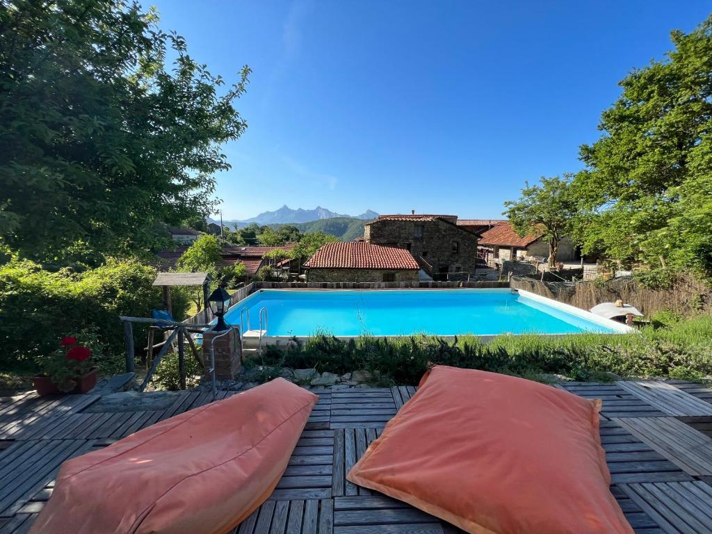 una piscina con 2 almohadas grandes en un patio en Borgo di Quarazzana holiday house for large groups Tuscany, en Agnino