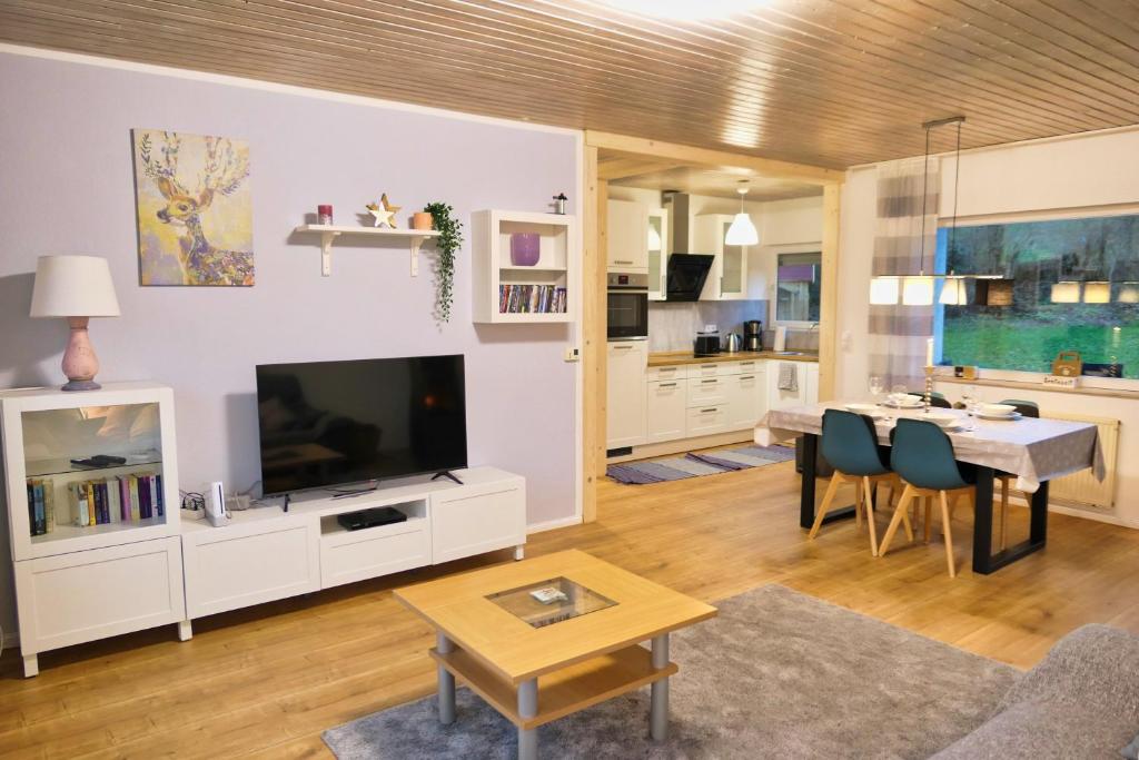 a living room with a television and a dining room at Apfelhaus beim Hennesee in Meschede