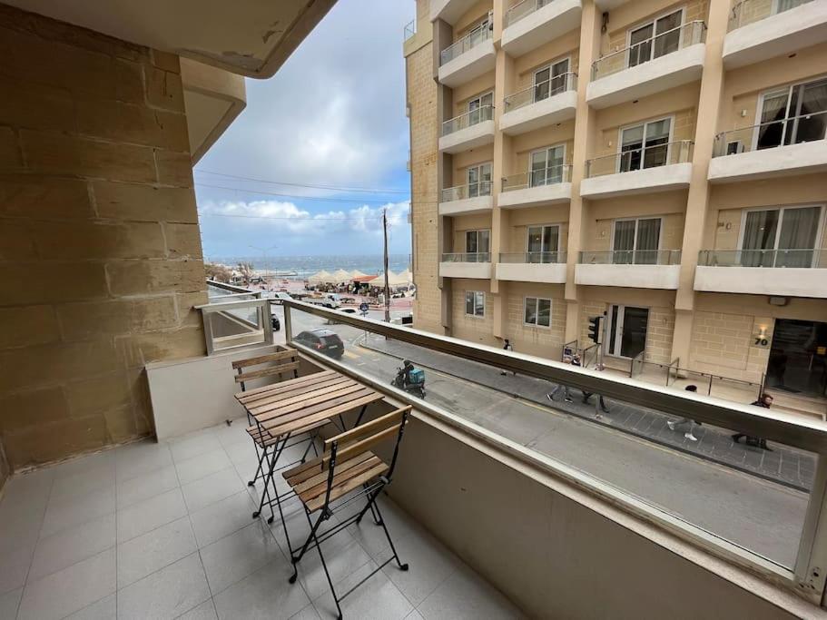 einen Balkon mit 2 Stühlen, einem Tisch und einem Gebäude in der Unterkunft Seaview 3 bedroom apartment in Sliema in Sliema