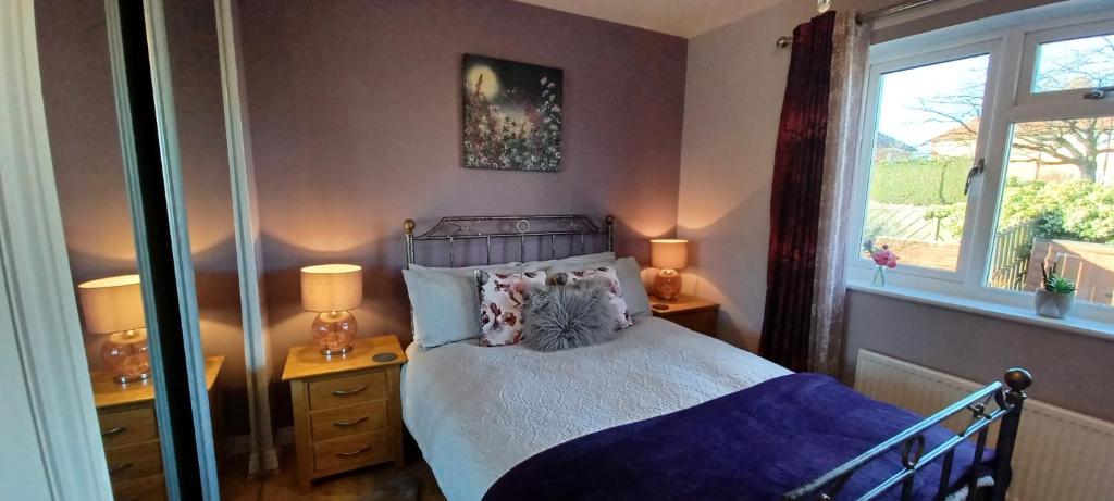 um quarto com uma cama, 2 candeeiros e uma janela em Cosy Retreat - house with double bedroom em Ripon