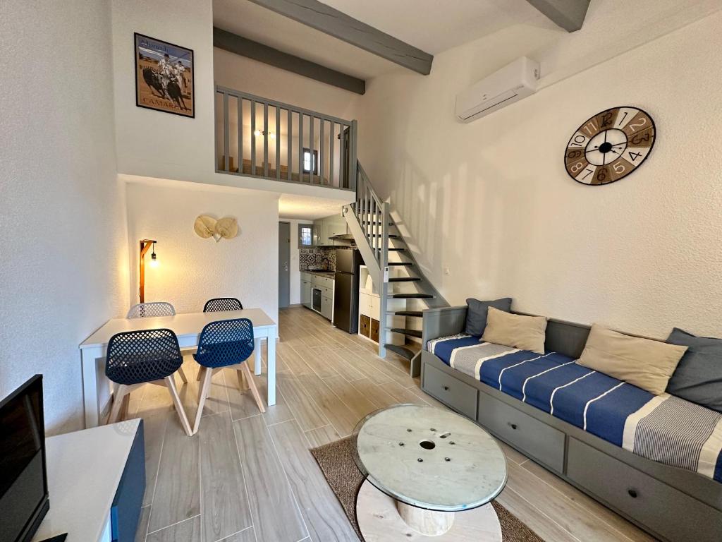 sala de estar con sofá y mesa en Appartement Duplex 4pers Climatisé - Location Valadié Camargue, en Saintes-Maries-de-la-Mer
