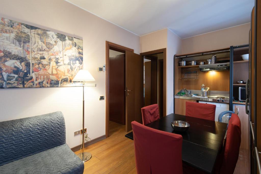 帕多瓦的住宿－Residence La Fenice，一间带桌子和红色椅子的用餐室