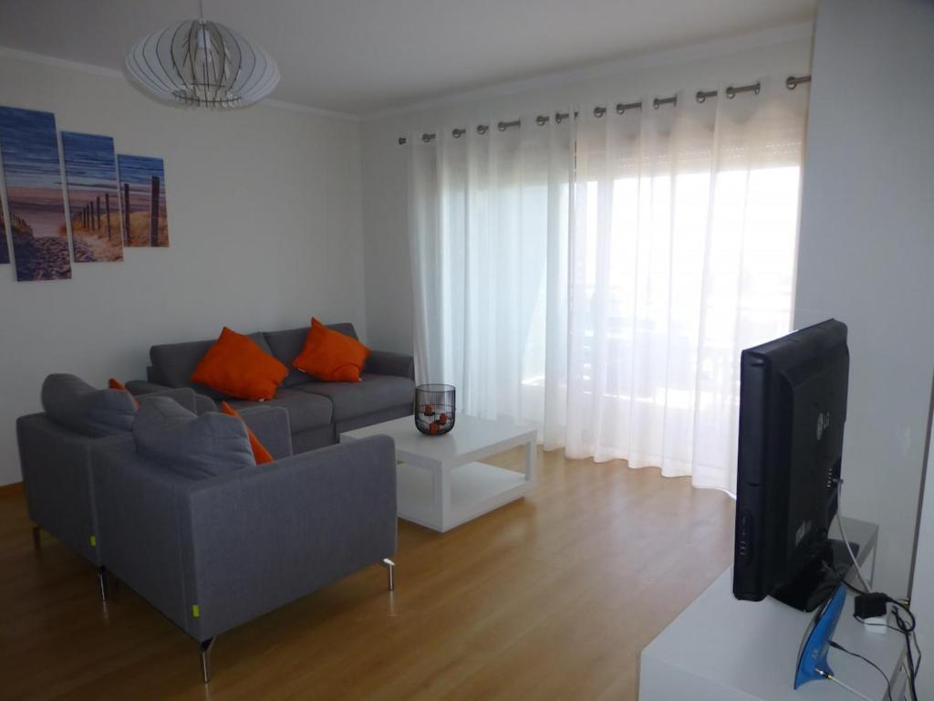 sala de estar con sofá y TV en Algarve T2 apartment with pool and balcony in Olhão, en Olhão