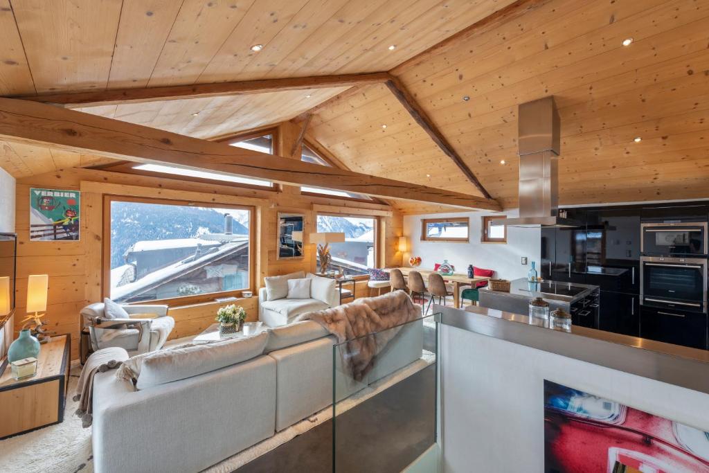 a living room with couches and a kitchen at Luxurious Chalet in Verbier in Verbier