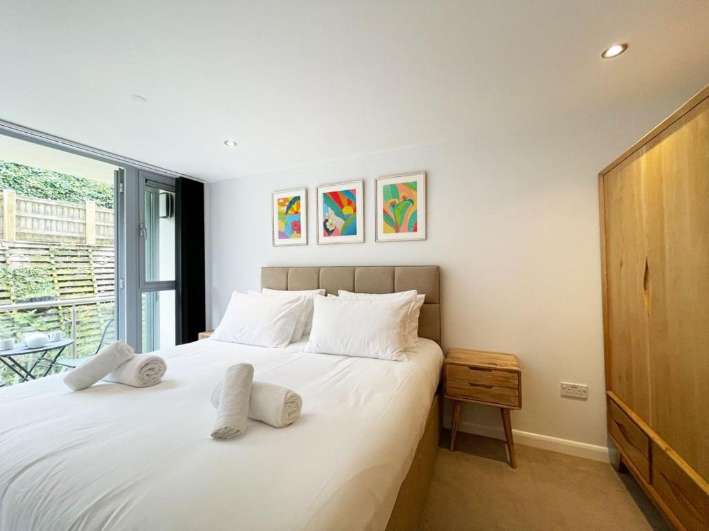 a bedroom with a bed with white pillows and a window at 8 Zinc in Newquay
